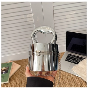 Detail of silver mirror acrylic cylindrical evening clutch with thick curved handle