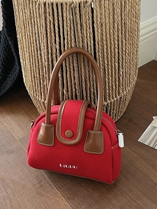 Red canvas and brown leather vintage small square bag with LIVUU branding on wood floor