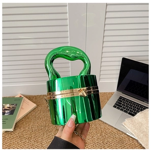 Detail of vivid green metallic cylinder clutch with unique irregular handle and gold chain
