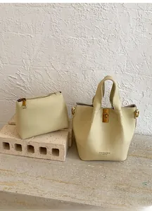 Détails de l'ensemble sac seau beige avec texture cuir litchi et fermoir métallique