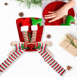 Christmas tree topper hat with sequin red elf legs and striped bow on white wood background