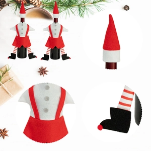 Kerst elf wijnfles hoes set met rode muts en gestreepte benen op houten achtergrond