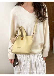Détail du sac seau jaune crème avec texture grainée et boucle de fermeture dorée
