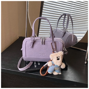 Detail of light purple pillow handbag with double zip closure and cute bear charm