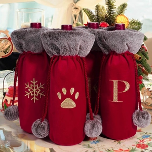 Detail of red velvet wine bottle bags with grey faux fur collars and gold embroidery