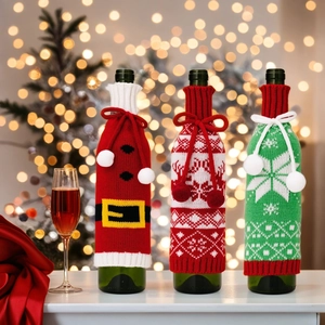 Three festive knitted Christmas wine bottle covers with snowflakes and pom-poms decor