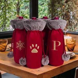 Detail of red plush wine bottle covers with grey faux fur collar and gold embroidery