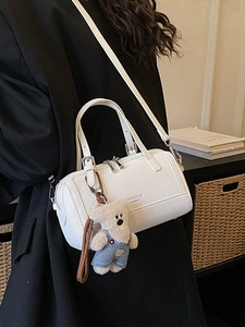 Fashionable white leather Boston bag with a cute bear charm and black wide shoulder strap