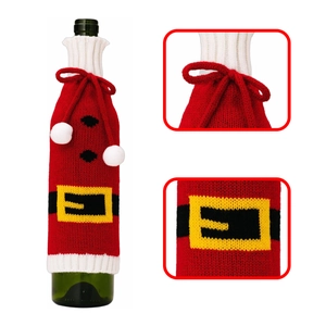 Close-up of knitted Christmas wine bottle cover details with plush balls and belt pattern