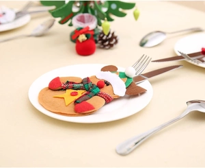 Gingerbread man cutlery holder on plate with festive Christmas dinner table setting