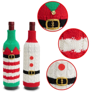 Detail view of knitted Christmas wine bottle covers showing bells and buckle textures