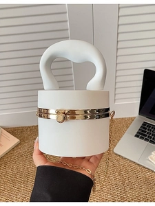 Chic white cylindrical acrylic handbag with sculptural handle and gold chain strap