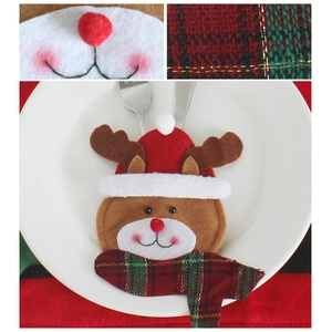 Christmas reindeer cutlery holder with red hat and scarf on white ceramic plate
