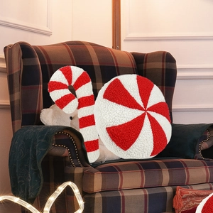 Close-up of candy cane and peppermint plush pillows in festive red and white sherpa fabric