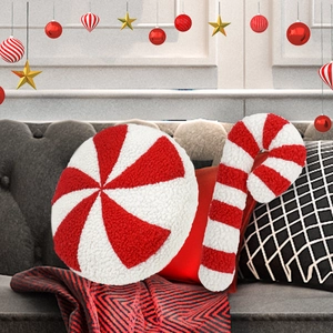 Christmas candy cane and peppermint plush pillows on a sofa with festive holiday decor