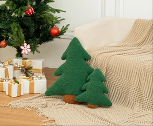 Detail of Christmas tree plush pillows in green sherpa fleece on a cozy white sofa