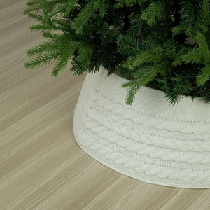 Detailed macro view of white cable knit Christmas tree skirt with textured pattern