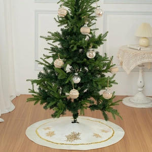 White Christmas tree skirt with golden snowflake patterns and matching glitter ball ornaments