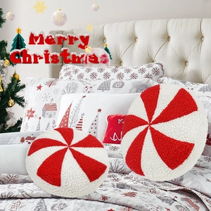 Detail of red and white spiral plush mint candy pillows in a festive Christmas bedroom