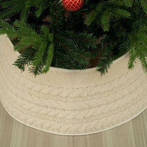 Creamy white cable knit Christmas tree collar on light wood floor for festive decor