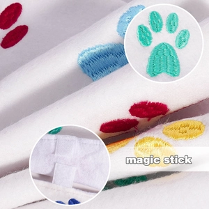 Detail of colorful paw embroidery and magic stick fastener on white plush fabric