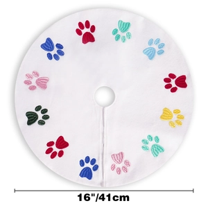 Detailed view of 16-inch white plush tree skirt with colorful embroidered dog paw prints