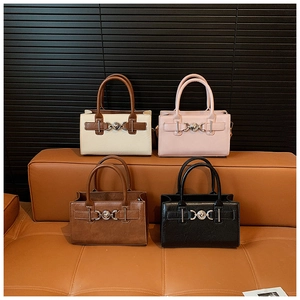 Detail of four colorful handbags with metallic heart buckles and dual handles for women