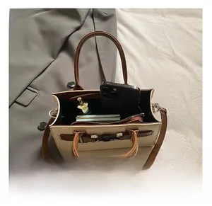 Detail showing the internal storage capacity of the leather crossbody bag with items
