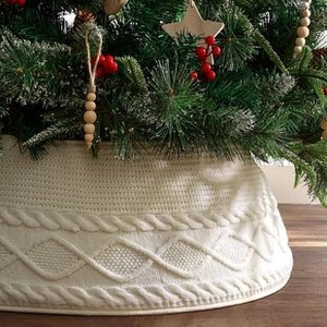 Detail of white knit Christmas tree collar with cable knit pattern and diamond textures