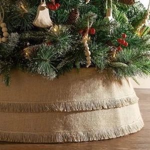 Detail of double-layer burlap Christmas tree skirt with bohemian fringe and festive decor