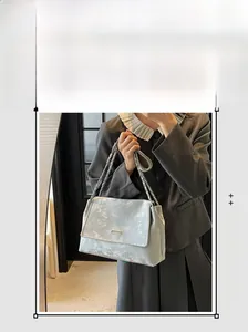Vue détaillée du sac à bandoulière argenté métallisé avec chaîne élégante et rabat chic
