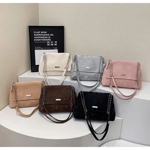 Plusieurs sacs à bandoulière élégants en six coloris exposés sur un présentoir blanc moderne