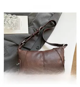 Detail showing brown lychee texture leather shoulder bag with silver metal hardware