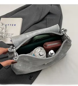 Vue intérieure montrant la grande capacité du sac fourre-tout gris à texture avec chaîne