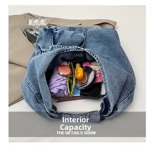 Macro view of blue denim shoulder bag showing internal capacity and durable texture