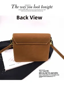 Detail view of brown textured leather crossbody bag with white contrast stitching