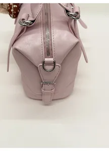 Detail of pink Boston bag showing lychee grain leather texture and silver hardware accents