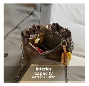 Detail view of mini glossy brown bag interior showing storage for phone and lipstick