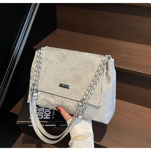 Détail du sac cabas argenté métallisé avec texture vintage et bandoulière chaîne