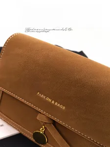 Close-up of brown retro shoulder bag with fine leather texture and gold metal detail