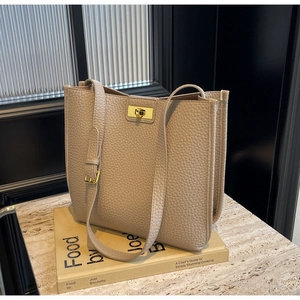 Détail du sac cabas en cuir grainé marron clair avec fermoir doré et côtés en accordéon
