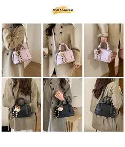 Matching display of a vintage Boston bag in pink and black with a bear charm