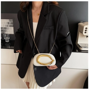 Detailed view of white acrylic half-moon bag with large golden C-shaped metallic clasp