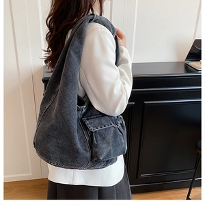 Side view of large grey washed denim tote bag with cargo pocket on female model