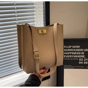 Détail de la texture cuir grainé et du fermoir doré sur un sac cabas beige