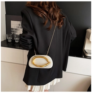 Model view of cream textured crossbody bag with gold hardware and chain strap