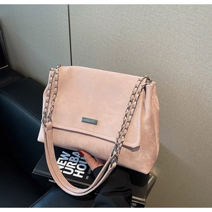 Détail du sac à bandoulière rose avec plaque logo argentée et bandoulière chaîne
