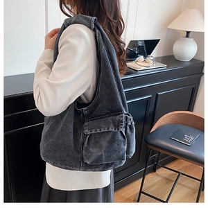 Detail of vintage gray washed denim hobo shoulder bag with functional side pockets