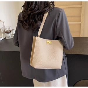 Détail du sac cabas beige en cuir PU avec boucle rotative dorée et bandoulière réglable