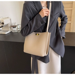 Détail du sac à main beige en cuir grainé avec fermoir doré et bandoulière élégante